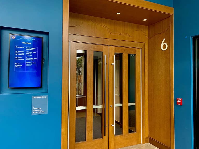 courtroom doors with digital signage solution next to it